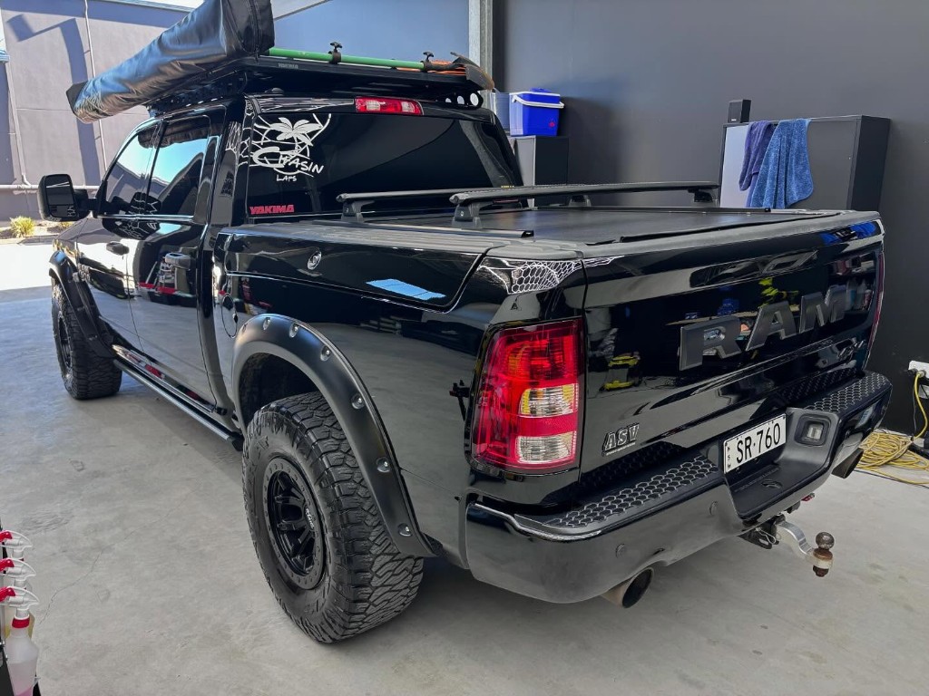 Black RAM pickup with hexagonal light reflection on hood