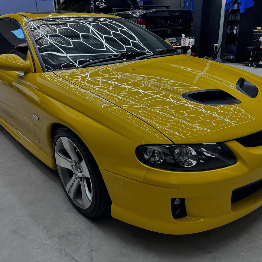 Yellow Holden Monaro with ceramic coating gloss reflection in Coastline workshop