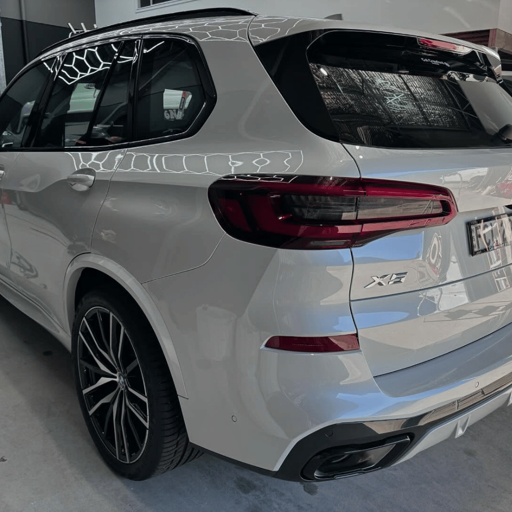 White BMW X5 with ceramic coating gloss reflection in workshop