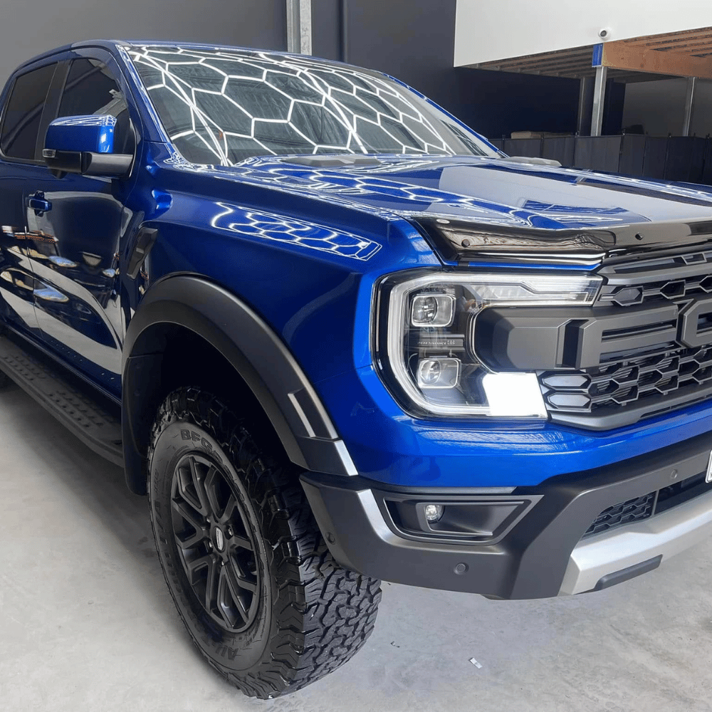 Blue Ford Ranger Raptor with paint correction gloss reflection in workshop