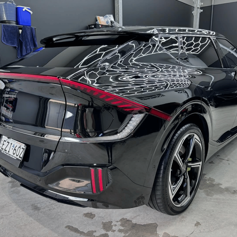 Black Kia EV6 with ceramic paint protection gloss reflection in workshop